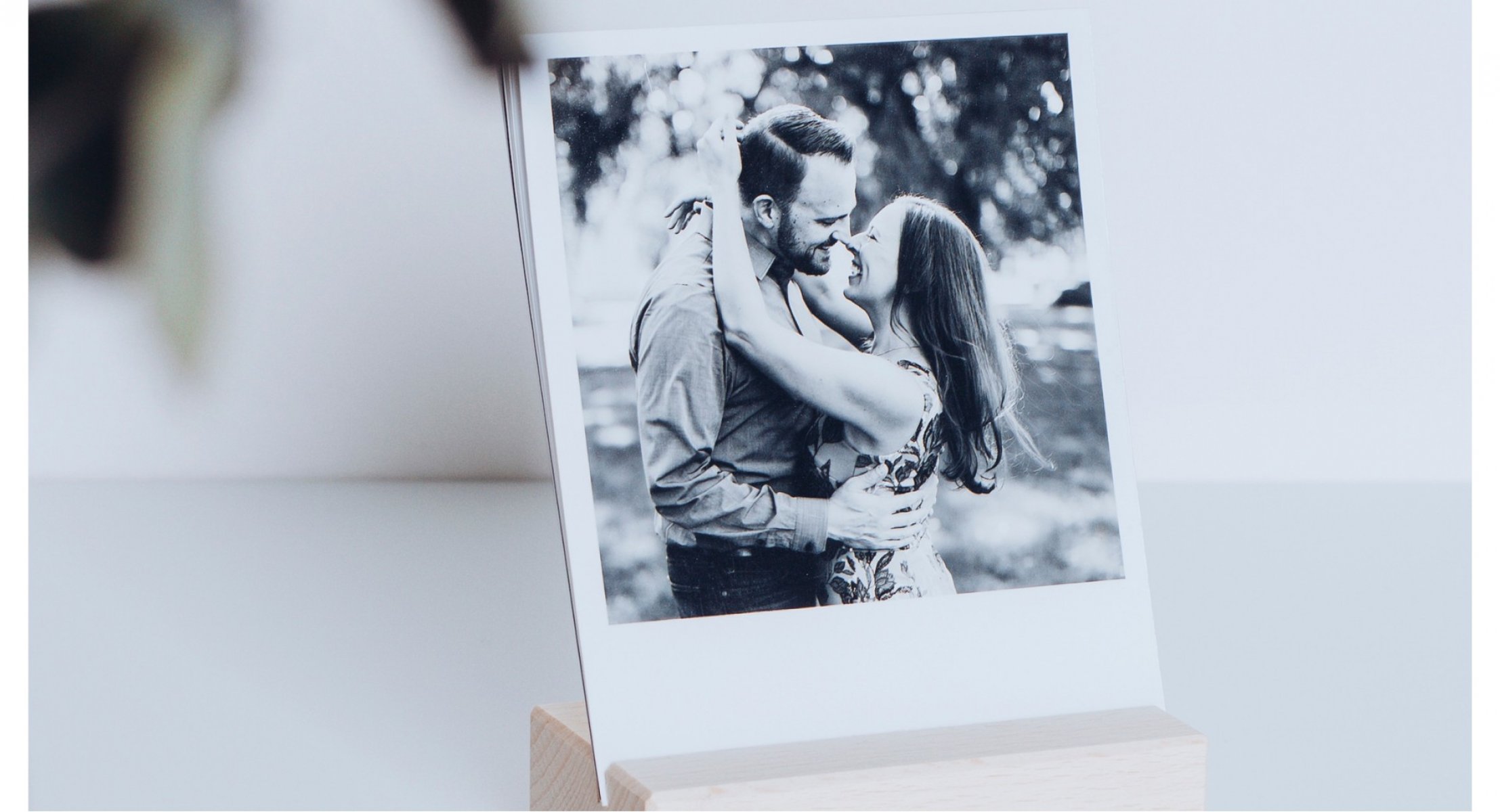 Mezinárodní den objímání 2022 - polaroidka s fotkou zamilovaného páru v dřevěném rámečku.